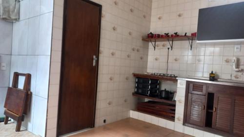 a kitchen with a door open to a kitchen with a counter at Kitnet em Aracaju para 3 pessoas in Aracaju