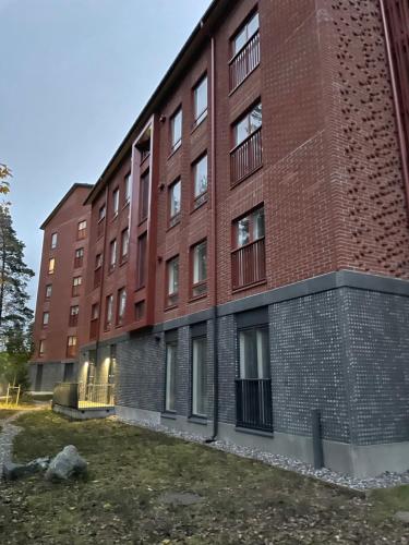a red brick building with windows on the side at Helsinki Airport Apartment in Vantaa