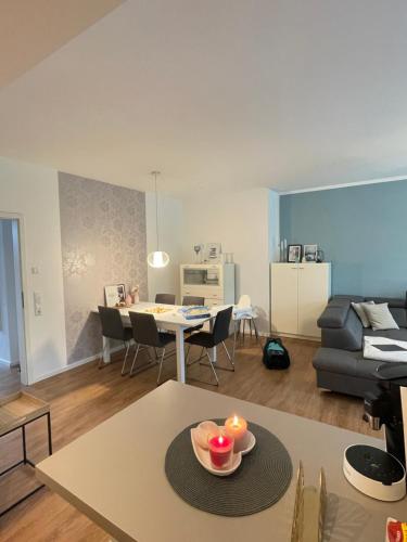 ein Wohnzimmer mit einem Tisch und einem Esszimmer in der Unterkunft Deluxe Apartment mit Stil und Carport Stellplatz in Oldenburg