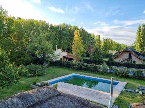 a backyard with a swimming pool and a house at Fabulosa y confortable cabaña in Mendoza
