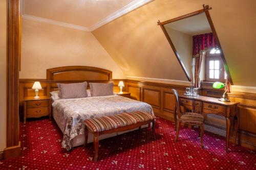 a bedroom with a bed and a dresser and a mirror at Galicia Nueva, castle hotel in Lučenec