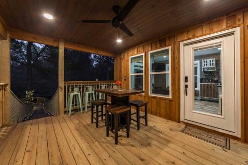 een veranda met een tafel en stoelen op een terras bij Romantic getaway in the treetops in Cabot