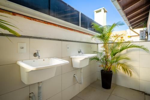 Baño con 2 lavabos y una maceta en Pousada Casa de Praia, en Bombinhas