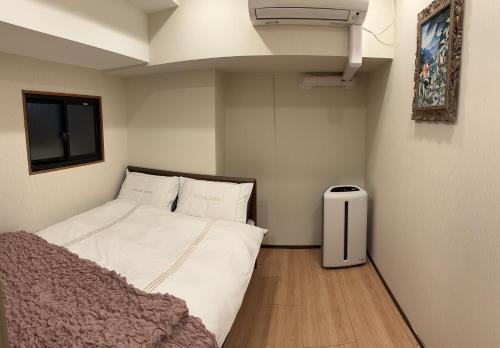 a small bedroom with a bed and a air conditioner at Shinjuku private homestay max 10ppl in Tokyo