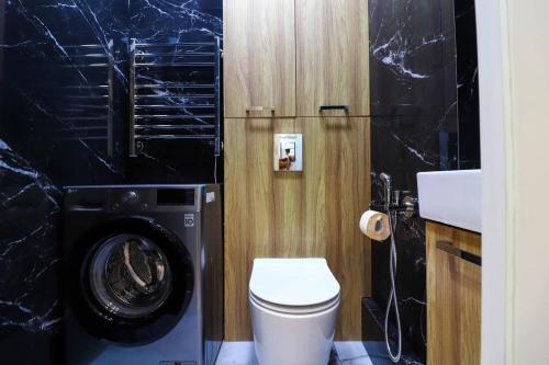 La salle de bains est pourvue d'un lave-linge et de toilettes. dans l'établissement Ultra comfort apartment in NRG Oybek, à Yakkasaray