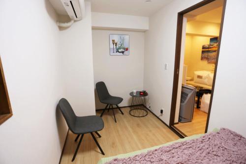 a bedroom with two chairs and a table and a mirror at Shinjuku private homestay max 10ppl in Tokyo