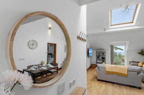 ein Wohnzimmer mit einem Spiegel und ein Wohnzimmer mit einem Sofa in der Unterkunft Stunning Sea View Whole Home In Torbay Close To Beach in Torquay