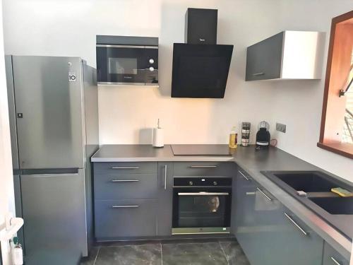 a kitchen with a stainless steel refrigerator and a sink at P'ti Paradise in Le Gosier