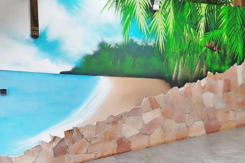 a mural of a beach and palm trees on a wall at P'ti Paradise in Le Gosier