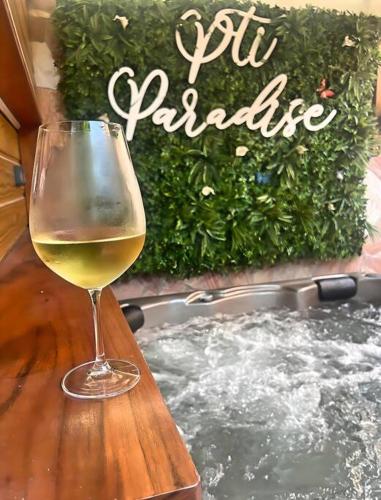 a glass of wine sitting on a table next to a hot tub at P'ti Paradise in Le Gosier