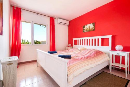 una camera rossa con letto bianco e tende rosse di Casa Limona ad Arona