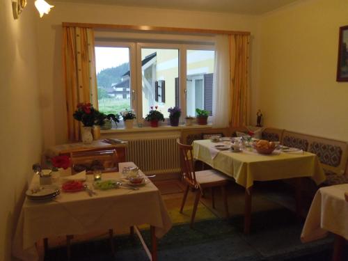 a dining room with two tables and a window at Haus Amalia in Strobl