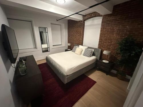 - une chambre avec un lit et un mur en briques dans l'établissement Large 3 bedroom in Flatiron, à New York