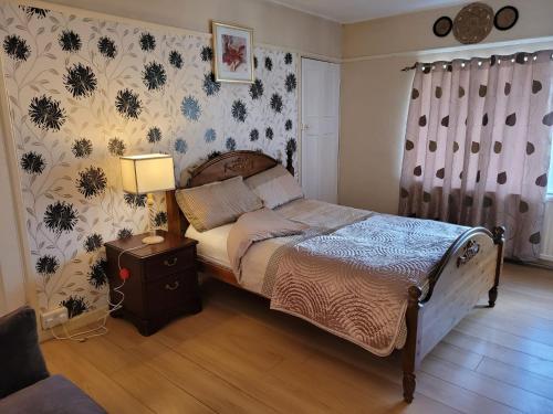 a bedroom with a bed with a night stand and a lamp at Abakwa House in Kingsthorpe