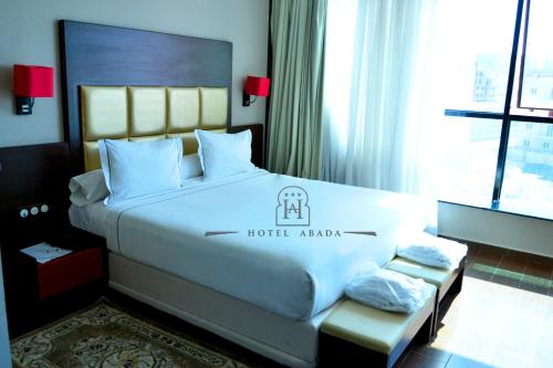 1 dormitorio con 1 cama con un logotipo de hotelanía en ABADA hôtel Mostagaem, en Mostaganem