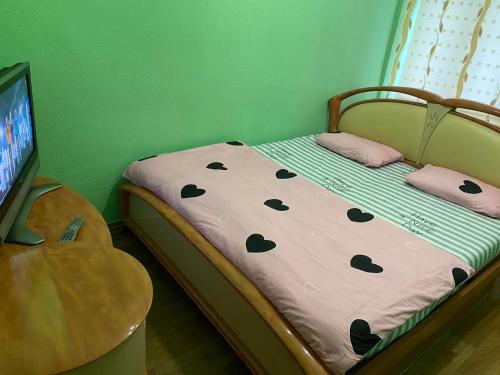 una piccola camera con un letto con una parete verde di Хостел Центр a Charkiv