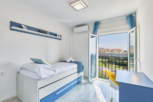 um quarto com uma cama, uma secretária e uma janela em VILLA by the beach. Pool, Priv Parking and Golf em Torre de Benagalbón