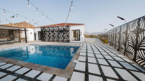 a villa with a swimming pool and a house at Hattah Palace View in Hatta