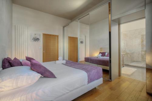 une chambre avec un grand lit blanc avec des oreillers violets dans l'établissement IMMOGROOM - T5 de standing - 130m - Terrace - Parking - AC, à Cannes