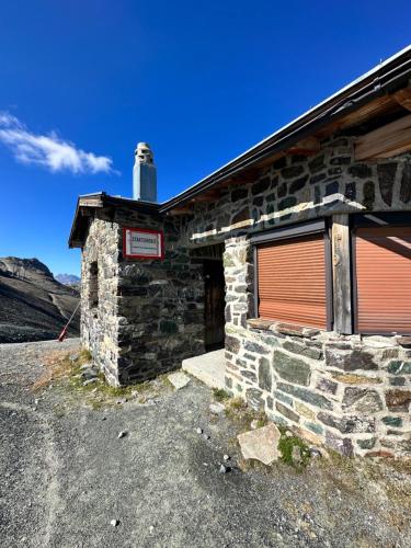a stone building with a garage with a red door at Apart Jil-Marie Studio 7 in Samnaun
