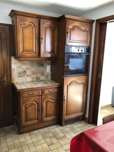 - une cuisine avec des placards en bois et un four dans l'établissement Metz Sud - A31 - Appartement rénové - 2 ch - 80 m2 - Entre Nancy et Luxembourg - Waves, à Jouy-aux-Arches