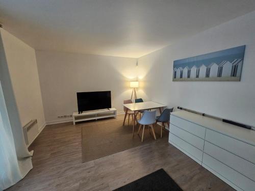 a living room with a table and a flat screen tv at Appartement champ elysee in Neuilly-sur-Seine