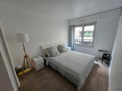 - une chambre blanche avec un lit et une fenêtre dans l'établissement Appartement super, à Neuilly-sur-Seine