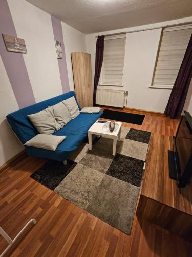 - un salon avec un canapé bleu et une table dans l'établissement Altstadtapartment, à Nordhausen