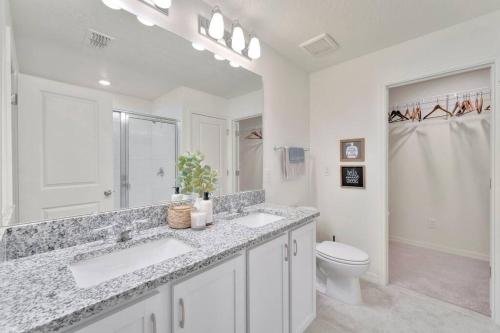 a white bathroom with two sinks and a toilet at Serene Sarasota Residence * By th Beach & Airport! in Sarasota
