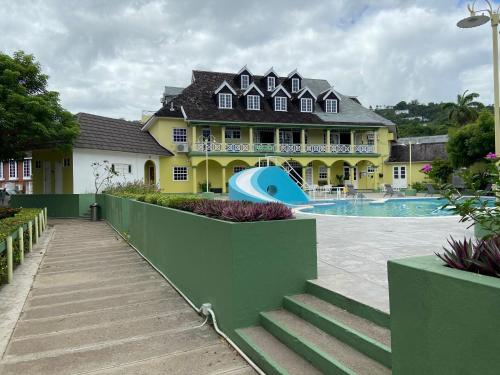奧喬里奧斯的住宿－Firefly at Sandcastle，一座大型黄色房子,设有游泳池和一座建筑