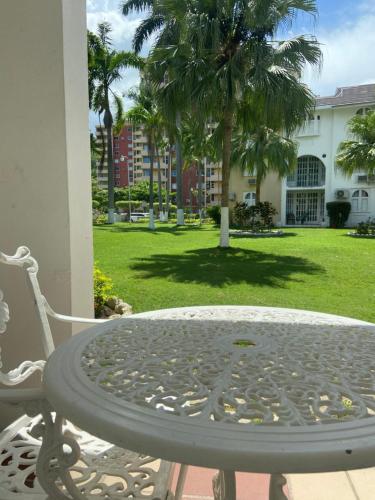 uma mesa e uma cadeira num pátio com um parque em Firefly at Sandcastle em Ocho Rios