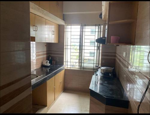 een kleine keuken met een wastafel en een raam bij Realx in Dhaka