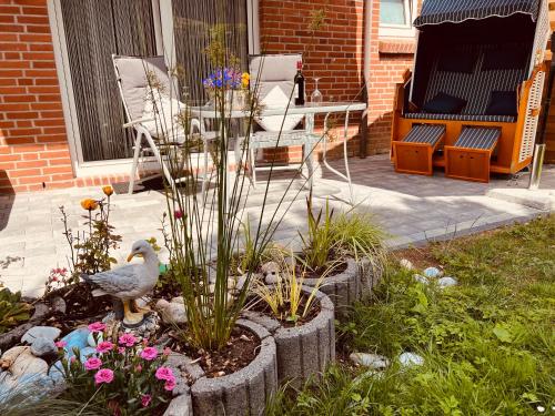 un pájaro está de pie en un jardín con flores en SeeLund - Meeresrauschen lauschen - ruhiges sonniges Apartment mit Garten und Terrasse nahe Strand und Ostsee en Schönhagen