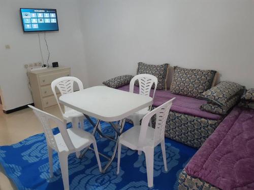 a living room with a table and chairs and a couch at Family House in Agadir