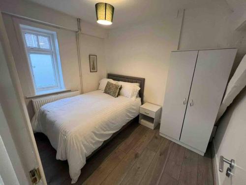 a small bedroom with a bed and a window at The Swan Apartment Ruislip in Ruislip