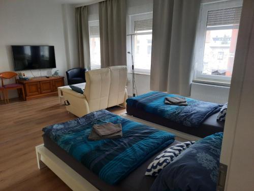 una sala de estar con 2 camas y una silla en Apartments Wagner, en Crimmitschau