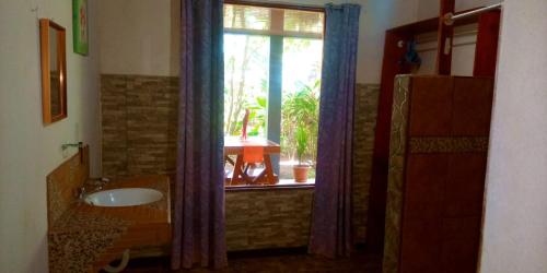 La salle de bains est pourvue d'un lavabo et d'une fenêtre. dans l'établissement Gecko de Tortuguero, à Tortuguero