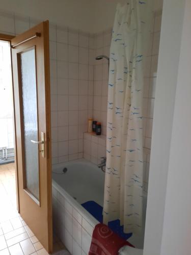 a bathroom with a tub and a shower curtain at Apartments Wagner in Crimmitschau