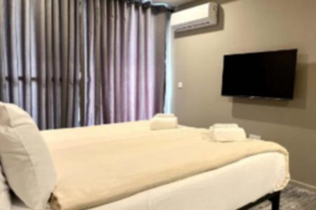 Habitación hospitalaria con cama y TV de pantalla plana en Kololi Sands Apartment 607, en Sere Kunda