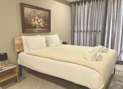 1 dormitorio con 1 cama blanca grande y toallas. en Kololi Sands Apartment 607, en Sere Kunda