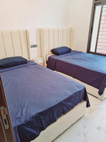 twee bedden naast elkaar in een slaapkamer bij Eden jardin in Nador