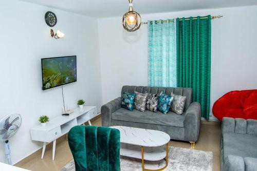 un soggiorno con divano e tavolo di Tina's 1 BR Apartment with Fast Wi-Fi, Parking and Netflix - Kisumu a Kisumu