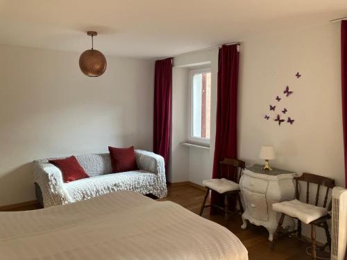 um quarto com uma cama, um sofá e uma janela em Casa Amélie em Caslano