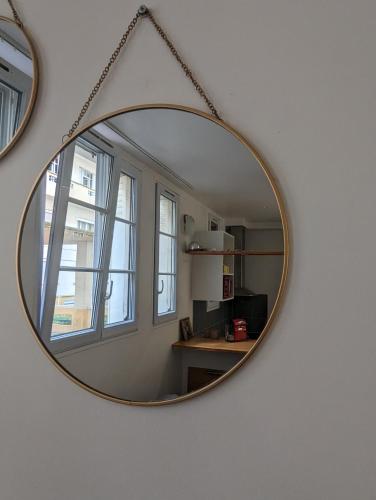 un miroir accroché au mur dans une pièce dans l'établissement Studio Jaurès - Equipped studio near Paris with private Bathroom, à Montrouge