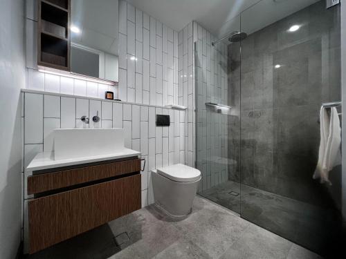 a bathroom with a sink and a toilet and a shower at Samma Flagstaff Luxury Apartments in Melbourne
