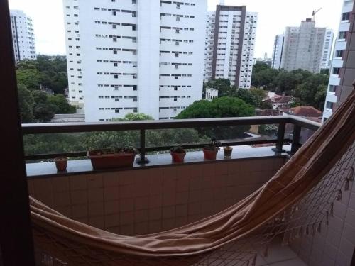a hammock on a balcony in a city at Completo com Ar-condicionado in Recife