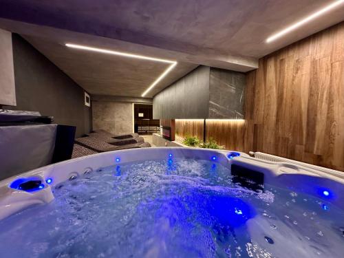 a large tub with blue water in a room at Hôtel Restaurant & Spa Les Planets in Les Rasses