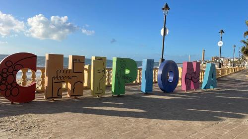a row of colorful signs on the beach at Casa Santuario de Regla in Chipiona