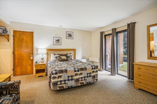 um quarto com uma cama, uma secretária e uma janela em Cedarbrook Queen Studio 110 em Killington