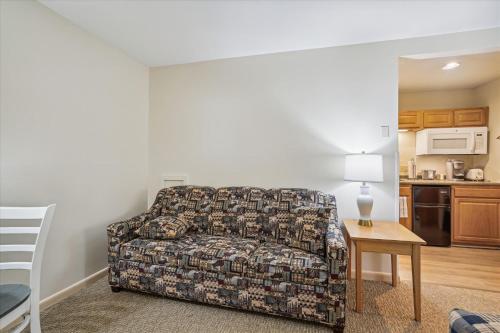 a living room with a couch and a table at Cedarbrook Queen Studio 110 in Killington